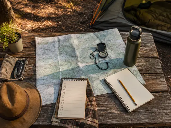 Camping trip planning with a map and compass